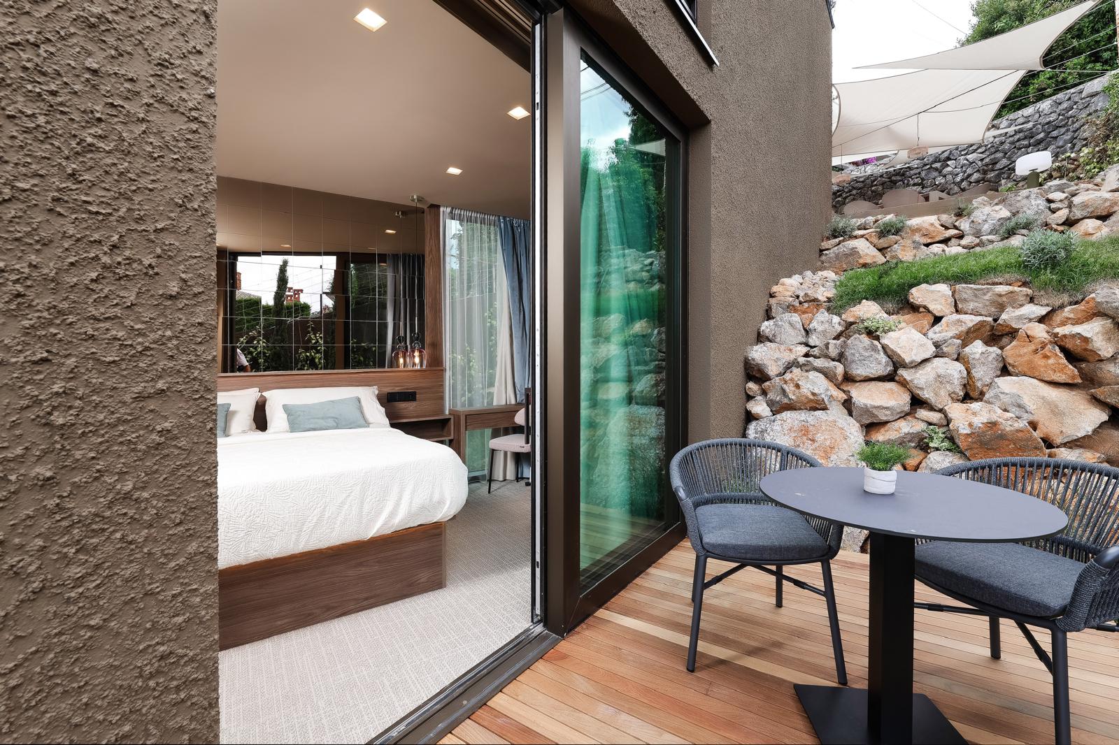 Private decked terrace with lounge seating beside the bedroom in Opatija