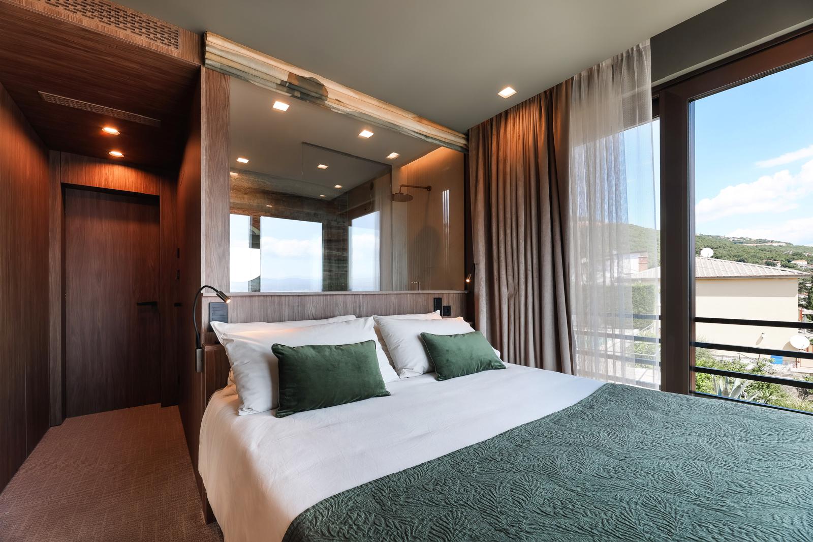 Bedroom with green accents, full-height glazing and private balcony