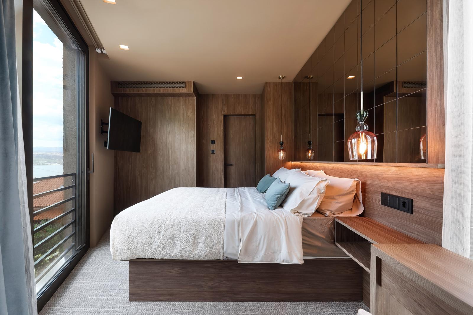 Bedroom with walnut panelling, mirrored wall and balcony with Kvarner Bay sea view